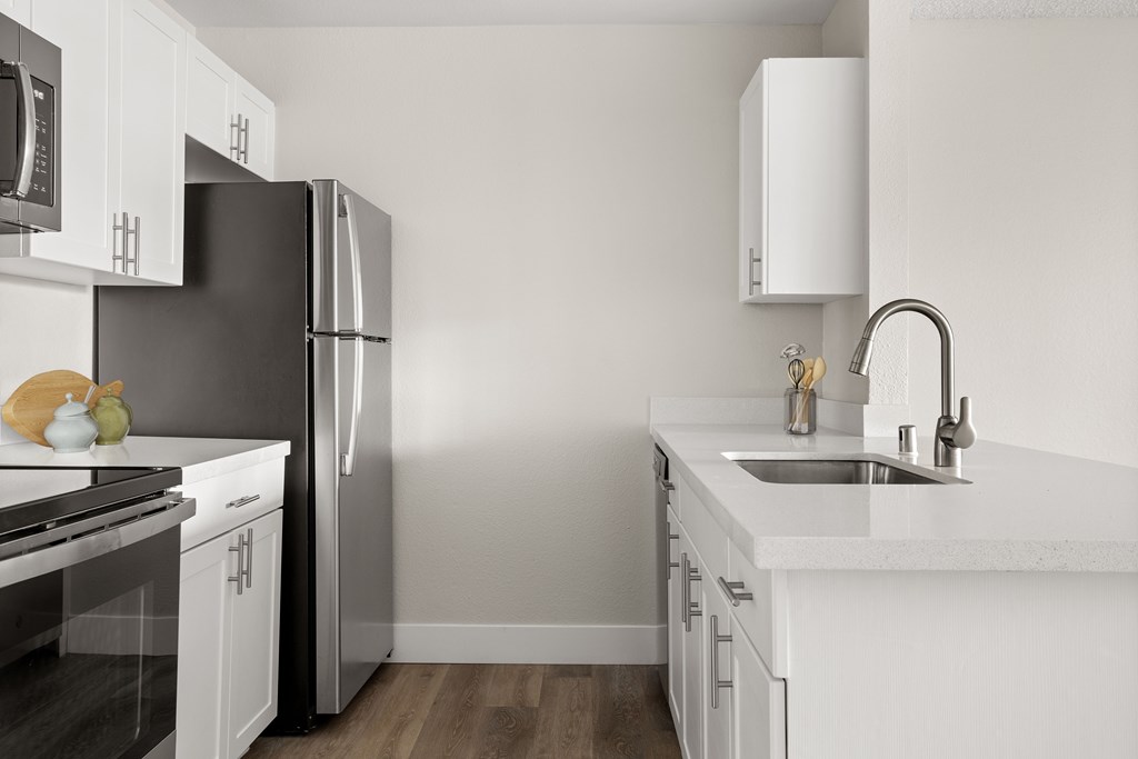 a kitchen with white cabinets and stainless steel appliances